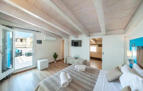um quarto com uma cama grande e uma janela grande em Rocca Doria em Castelsardo