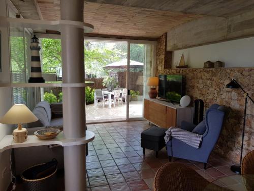een woonkamer met een tv en een tafel en stoelen bij MACH HOUSE you will like it ! in Tamariu