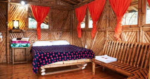 1 dormitorio con 1 cama en una habitación de madera en Hotel Guatape Adrianas Bambu, en Guatapé