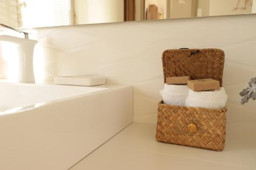 een badkamer met handdoeken op een plank en een mand bij Le Mas Joséphine in Saint-Rémy-de-Provence