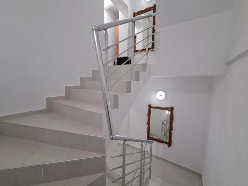 a staircase with a metal railing and a mirror at Guest Rooms Kostovi in Nesebar