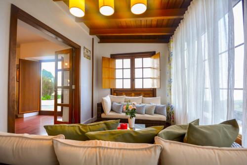 ein Wohnzimmer mit grünen Möbeln und einem Sofa in der Unterkunft Villa Finca Los Castanos - Panoramic View in Santa Cruz de Tenerife
