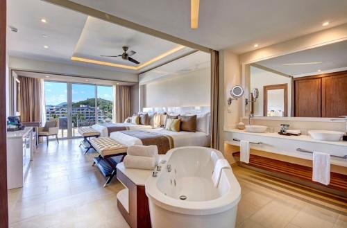 a hotel room with a bed and a bath tub at Royalton Hideaway Saint Lucia, An Autograph Collection All-Inclusive Resort - Adults Only in Gros Islet