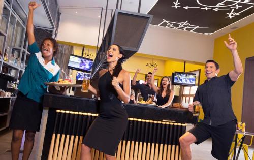 a group of people dancing at a bar at Royalton Hideaway Saint Lucia, An Autograph Collection All-Inclusive Resort - Adults Only in Gros Islet