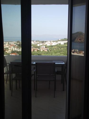a view from the balcony of a room with a table and chairs at Thea Apartment in Agia Marina Nea Kydonias