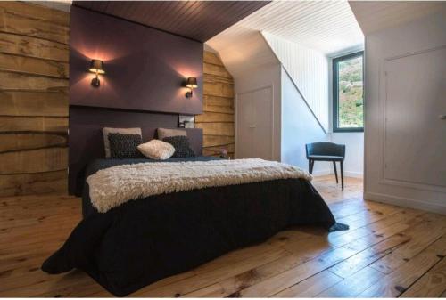 une chambre avec un grand lit avec un plancher en bois dans l'établissement Maison du cap ****, à Saint-Lary-Soulan
