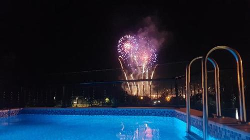 uma piscina com fogo de artifício a explodir no céu em Sunshine Apartment with Private Pool and Parking em Kotor