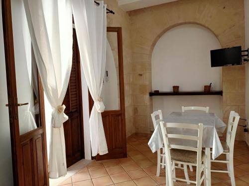 a dining room with a table and chairs and an open door at Case Vacanze Mariposa in Favignana
