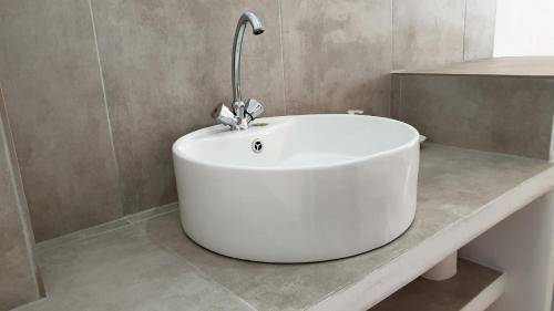a white bath tub sitting on a counter in a bathroom at ILIADA-ODYSSEAS RESORT in Perivolos