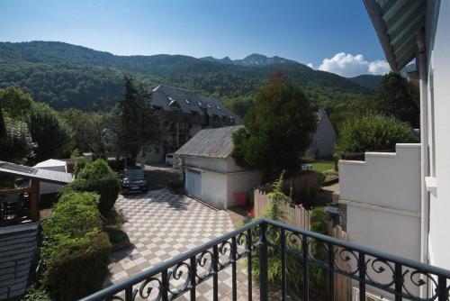 - un balcon offrant une vue sur une maison avec des montagnes dans l'établissement Maison du cap ****, à Saint-Lary-Soulan