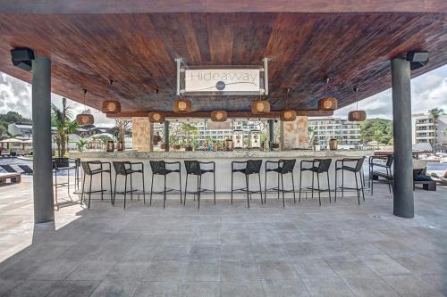 a bar with bar stools under a wooden ceiling at Royalton Hideaway Saint Lucia, An Autograph Collection All-Inclusive Resort - Adults Only in Gros Islet