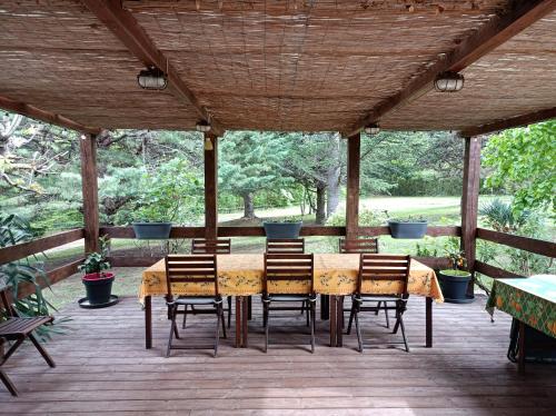 une table à manger et des chaises sur une terrasse en bois dans l'établissement Les Eaux Tranquilles, à Belvianes-et-Cavirac