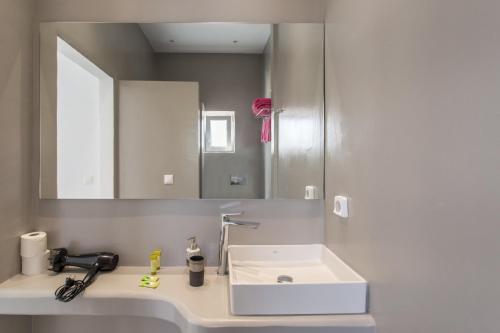 a bathroom with a white sink and a mirror at Irini Rooms in Naousa