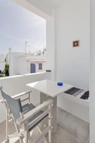 a white table and chair in a room with a view at Irini Rooms in Naousa
