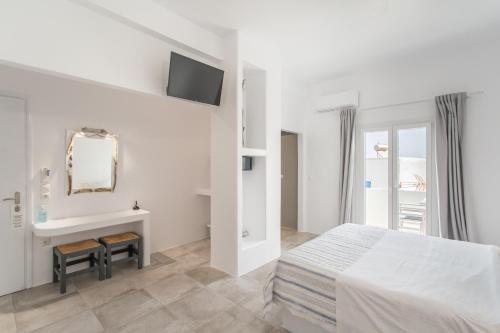 a bedroom with a bed and a sink and a mirror at Irini Rooms in Naousa