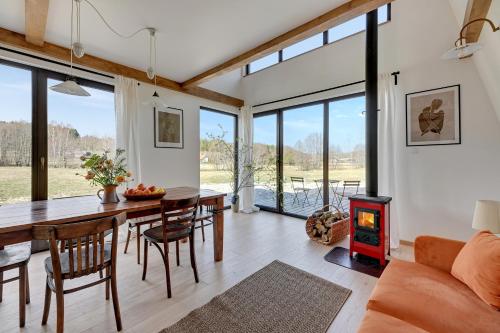 a living room with a table and a wood stove at Domek Trzy Rzeki in Załęże