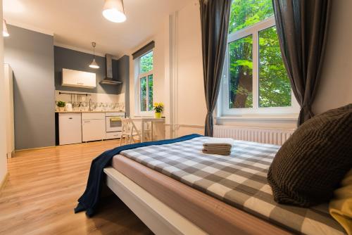een slaapkamer met een bed met een geruite deken bij Light Studio Apartment in Liepāja