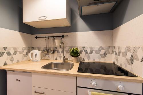 een keuken met een wastafel en een aanrecht bij Light Studio Apartment in Liepāja