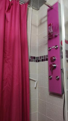 a bathroom with a shower with a pink shower curtain at SUPER CHAMBRE ÉQUIPÉE chez l habitant in Le Gosier