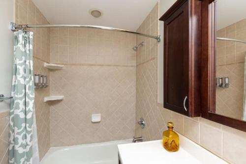 a bathroom with a shower and a bath tub with a sink at North Park Studio Bungalow in San Diego