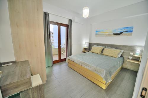 a bedroom with a bed and a view of the ocean at Ammos Apartment - brand new, stylish, by the beach in Kissamos