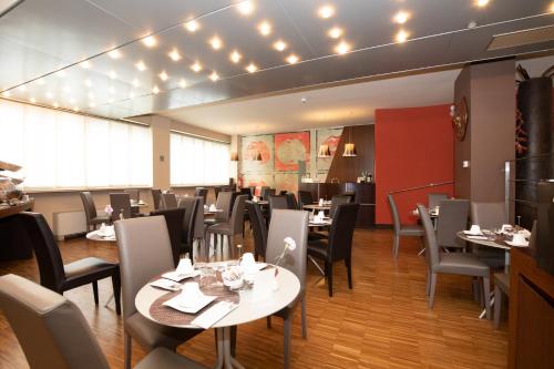 a dining room with tables and chairs and lights at Hotel Aleramo in Asti