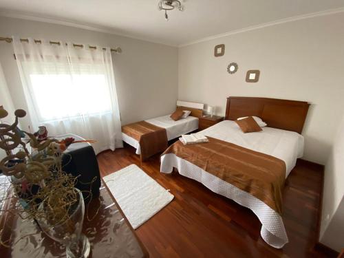 una camera d'albergo con due letti e una finestra di Casa Lúcia a Nazaré