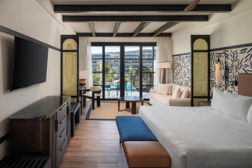 a hotel room with a bed and a tv and a living room at Ocean Eden Bay - Adults Only - All Inclusive in Falmouth