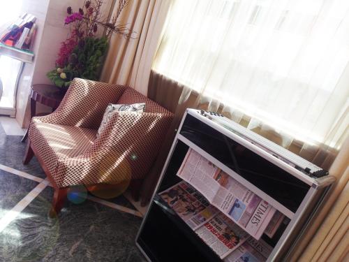 a living room with a chair and a window at Lake Hotel in Xindian