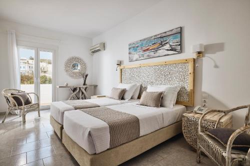 a bedroom with a large bed and two chairs at Capetan Giorgantas in Adamas