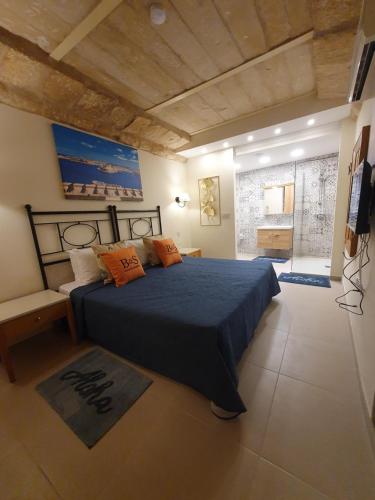 1 dormitorio con cama azul y almohadas de color naranja en B&S Accommodation Apartment 601 en Għaxaq