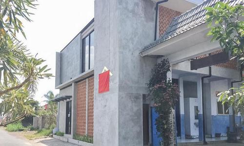 a building with a red flag on the side of it at RedDoorz near Wisata Paribendo Lawang in Lawang
