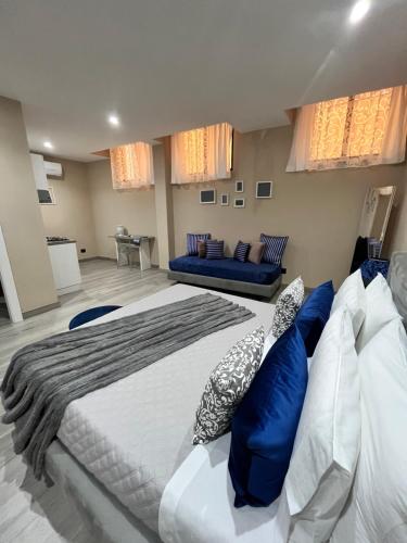 1 dormitorio con 1 cama grande con almohadas azules en CB Rooms, en Termini Imerese