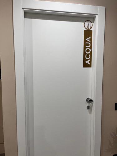 Una puerta blanca con un cartel. en CB Rooms, en Termini Imerese