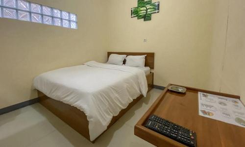 馬老奇的住宿－RedDoorz @ Merauke City Center，一间卧室配有一张带键盘的床和一张书桌