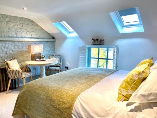 1 dormitorio con 1 cama y 1 mesa con sillas en The Loft in the Malt Barn Chipping Campden en Mickleton