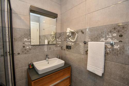 uma casa de banho com um lavatório e um espelho em Duygu Apart spellbinding sea views em Fethiye