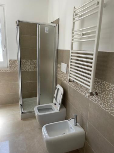 a bathroom with a shower and a toilet and a sink at Villa Portinente in Lipari