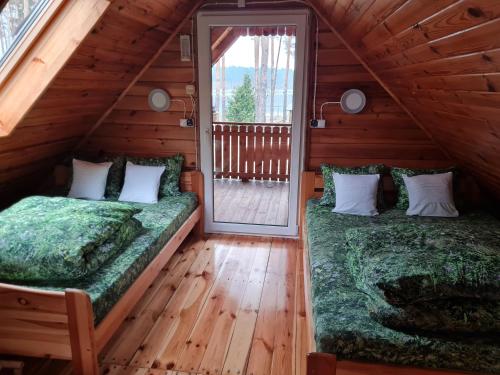 a bedroom with two beds in a log cabin at Pod Czarnym Dzięciołem - dom z widokiem i prywatną balią in Mazówki