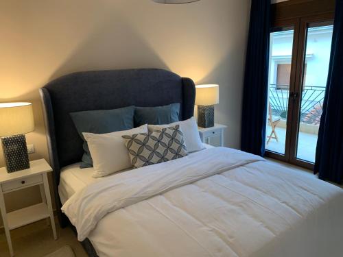 een slaapkamer met een bed met 2 lampen en een raam bij Divine Meteora Luxury midtown apartment in Kalabaka