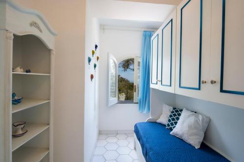 a blue couch in a room with a window at YourHome - Relais Casa degli Angeli in Positano