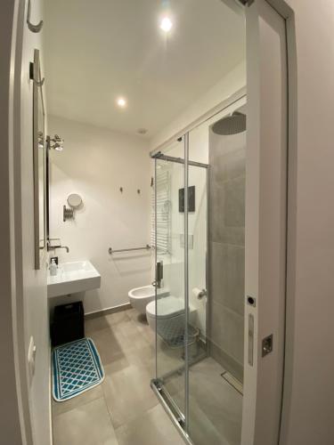 a bathroom with a glass shower and a toilet at Mimma's Ground Floor in Rome