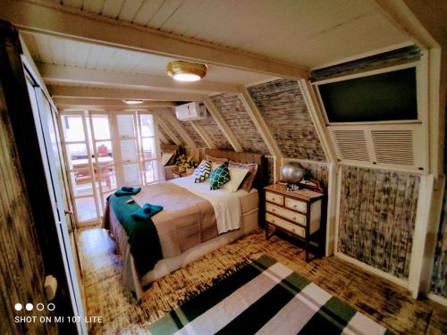 a bedroom with a bed and a tv in it at Pousada Águas da Serra in Araras Petropolis