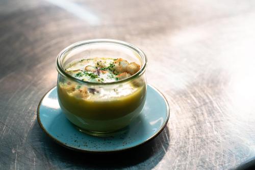a cup of food on a plate on a table at Ott's Hotel Weinwirtschaft & Biergarten Weil am Rhein/Basel in Weil am Rhein