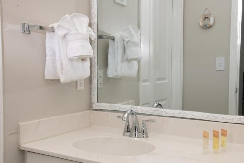 a bathroom with a sink and a mirror and towels at Shores of Panama Resort in Panama City Beach