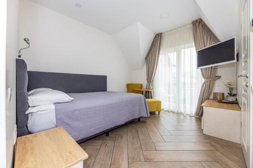 Un dormitorio con una cama y suelo de madera. en Palanga Deluxe 2, en Palanga