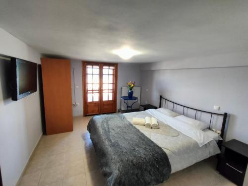 a bedroom with a large bed and a television at EndlessSunrise (2) Apartments by the sea in Míloi