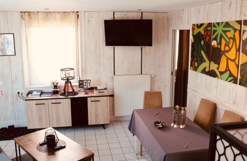 une chambre avec une table et une cuisine avec une télévision dans l'établissement Duplex, 2 Sdb, 2 chambres, dans une impasse en centre-ville, à Gérardmer