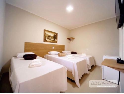 a room with two beds with white sheets at HOTEL MANTORAMOS in Bilac