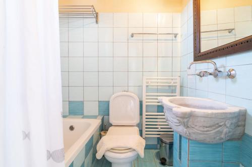 a bathroom with a tub and a toilet and a sink at Strofilia Authentic Villas in Skinária